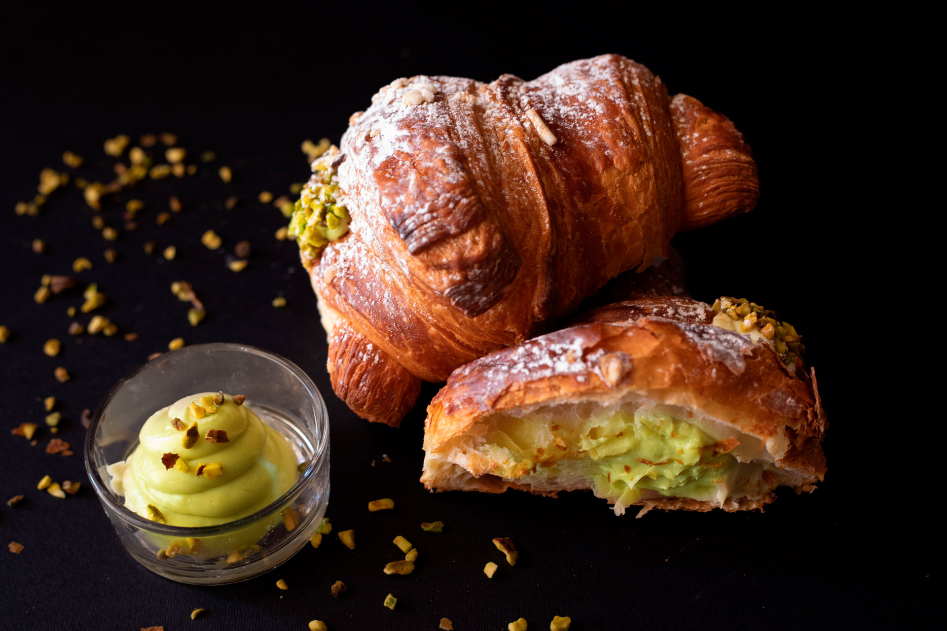 Cornetti al pistacchio con crema su fondo scuro