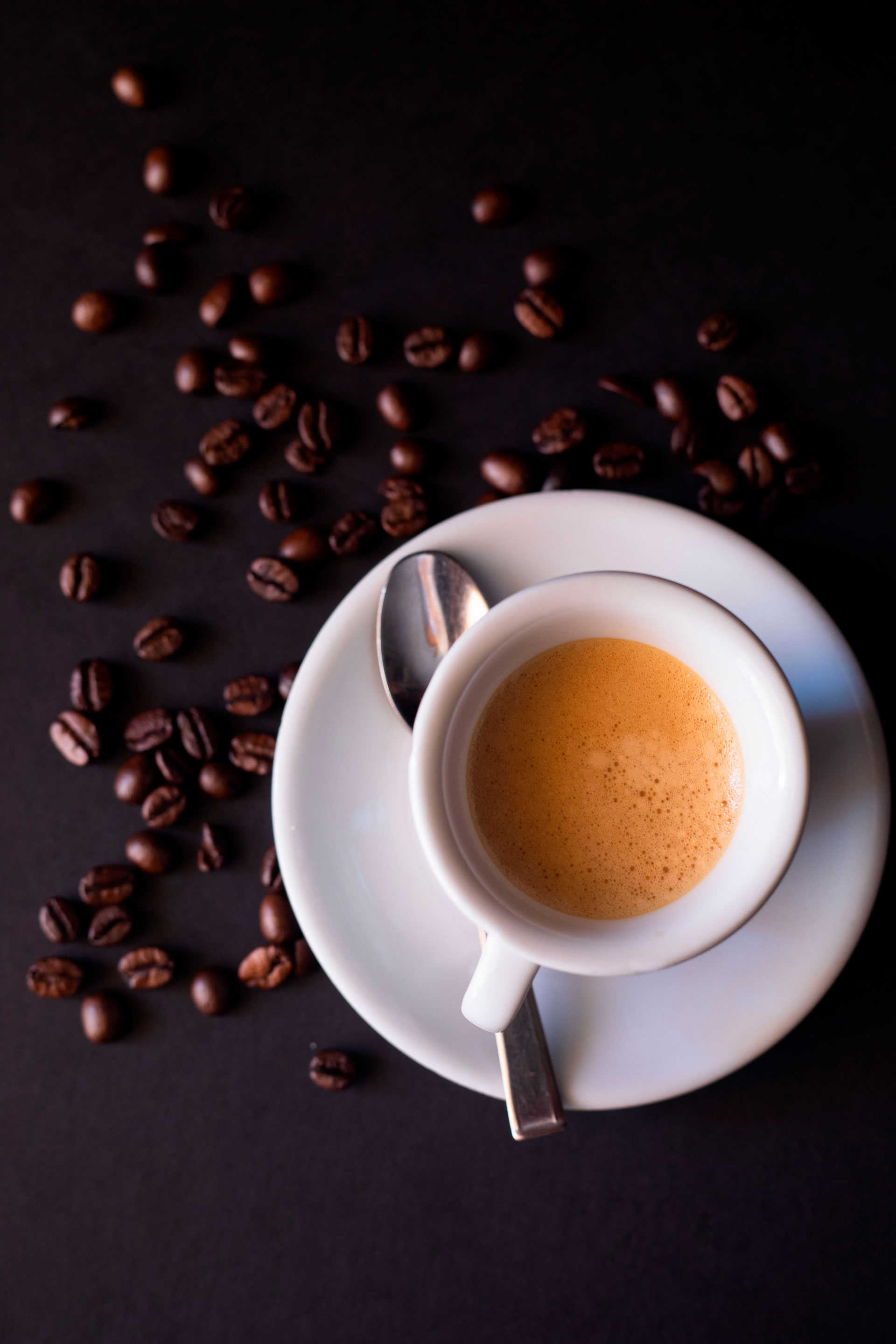 Tazzina di espresso vista dall'alto con chicchi