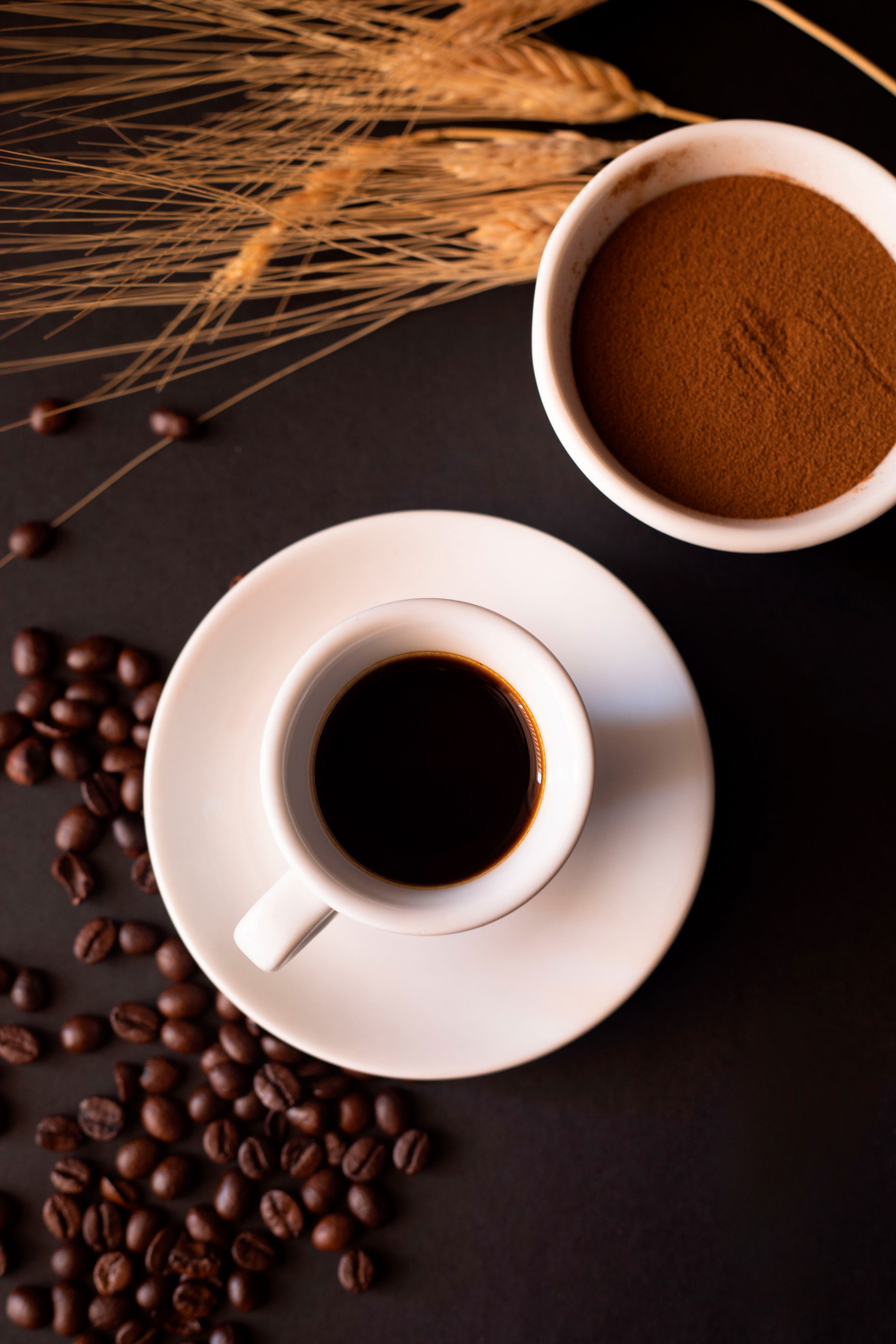 Espresso su piattino nero con chicchi sparsi
